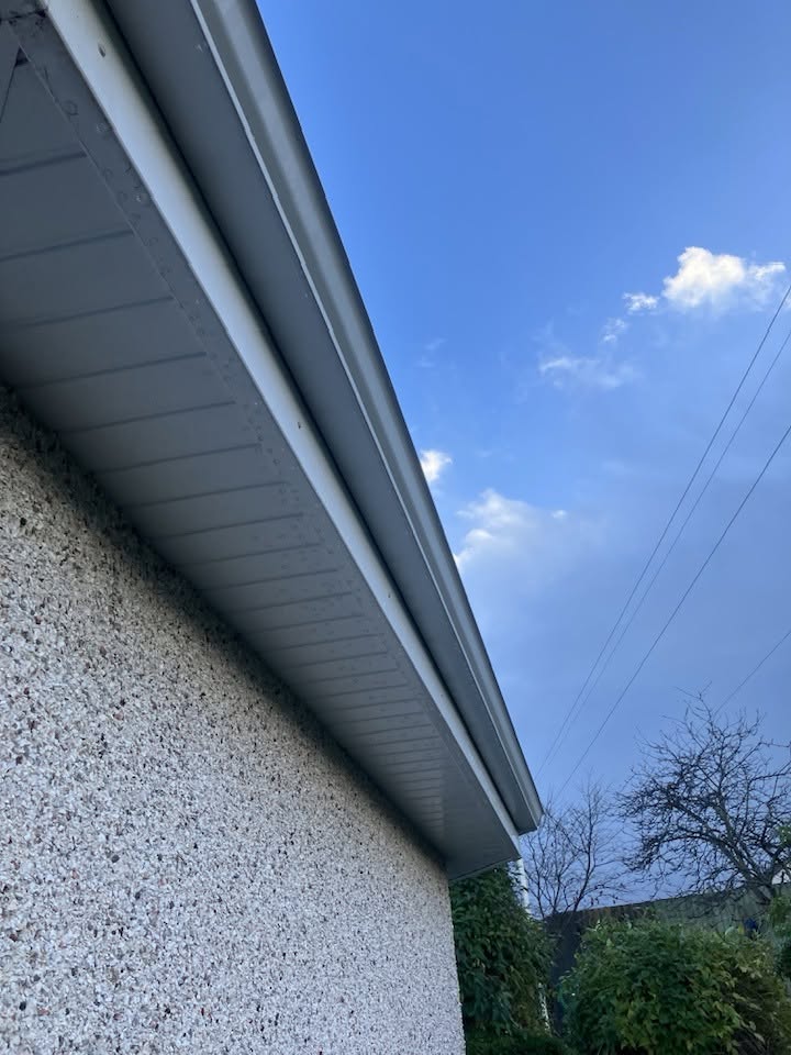 Clean house guttering and fascia against a blue sky after gutter cleaning
